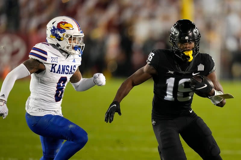 Iowa State wide receiver Daniel Jackson (16) runs from Kansas cornerback Kwinton Lassiter (8) after catching a pass during the second half of an NCAA college football game, Saturday, Nov. 4, 2023, in Ames, Iowa. Kansas won 28-21. | Charlie Neibergall