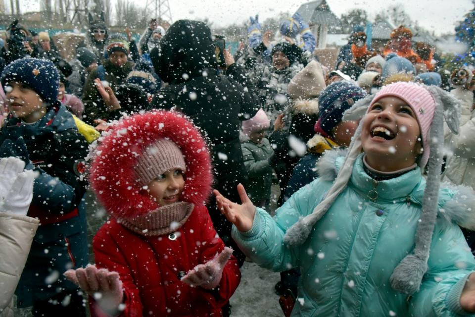 Girls and boys enjoy the snow during exercises at the Christmas tree outside the house of the Podilskyi Magician at Podilskyi Zoo, Vinnytsia, west-central Ukraine, on Dec. 6, 2023. (Oleksandr Lapin/Ukrinform/Future Publishing via Getty Images)