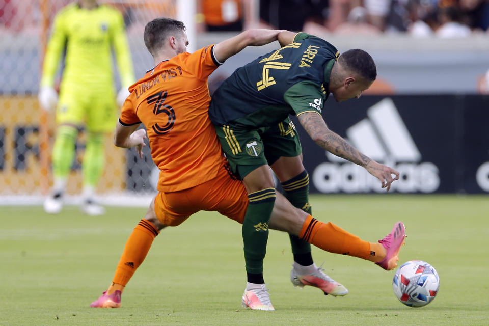 Houston Dynamo defender Adam Lundqvist (3) kicks through the block by Portland Timbers midfielder Marvin Loria (44) during the first half of an MLS soccer match Wednesday, June 23, 2021, in Houston. (AP Photo/Michael Wyke)