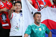 <p>A Germany fan looks dejected as a Korea fan gives a thumbs up at the end of the 2018 FIFA World Cup Russia group F match between Korea Republic and Germany at Kazan Arena on June 27, 2018 in Kazan, Russia. (Photo by Matthew Ashton – AMA/Getty Images) </p>