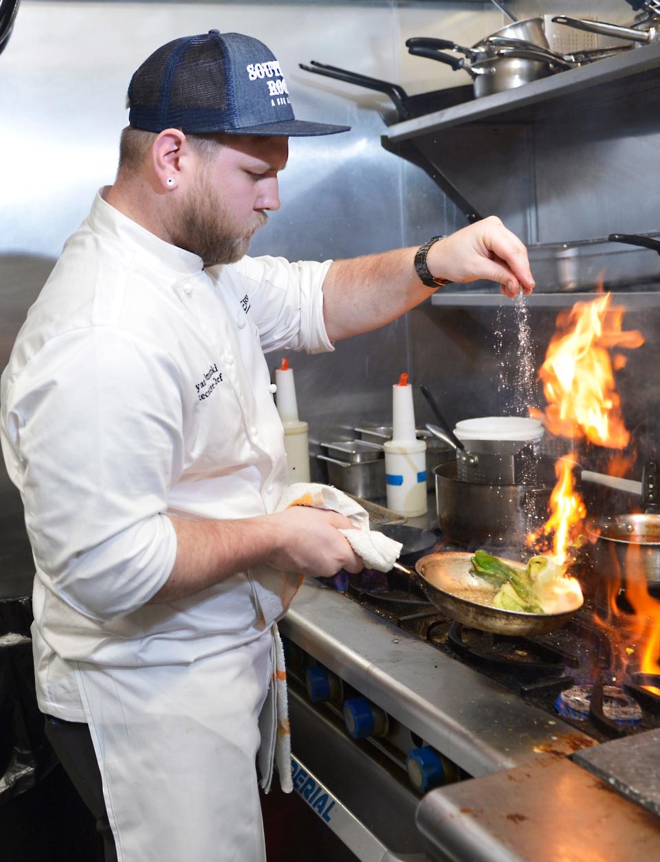 Executive Chef Ryan Smutzi adds his touch to a meals in the kitchen of the Level 10 restaurant. 