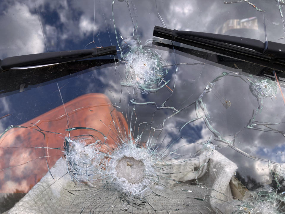 A bullet-marked windshield is seen amid cars abandoned by residents who fled the war in Irpin, Ukraine, on Monday, April 11, 2022. Heartened by Russia’s withdrawal from the capital region, some residents have been coming to what’s left of home. (AP Photo/Cara Anna)