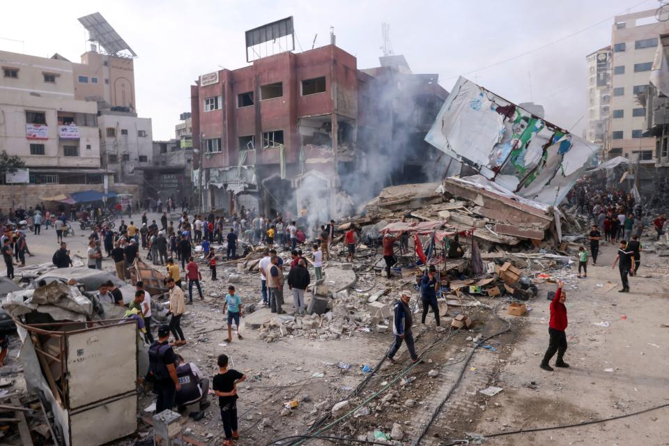 Palestinos inspeccionaban los escombros de un edificio derrumbado en la ciudad de Khan Yunis, que fue fuertemente bombardeada, en el sur de la Franja de Gaza. (Foto de SAID KHATIB/AFP vía Getty Images)