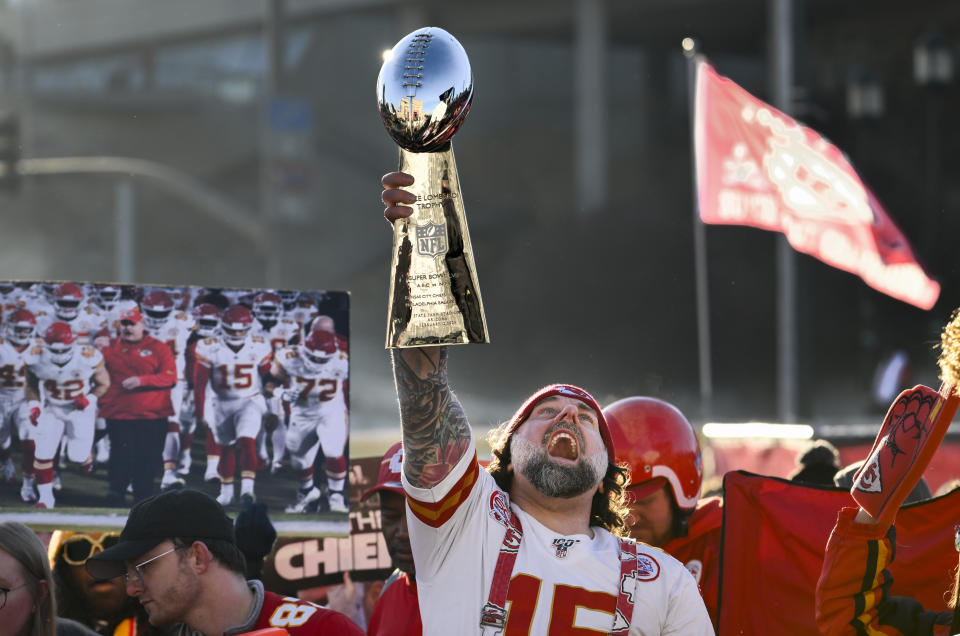 Un fanático de los Kansas City Chiefs celebra con una réplica del trofeo Vince Lombardi durante el mitin de victoria de los Kansas City Chiefs en Kansas City, Missouri, el miércoles 14 de febrero de 2024. (Foto AP/Reed Hoffmann)