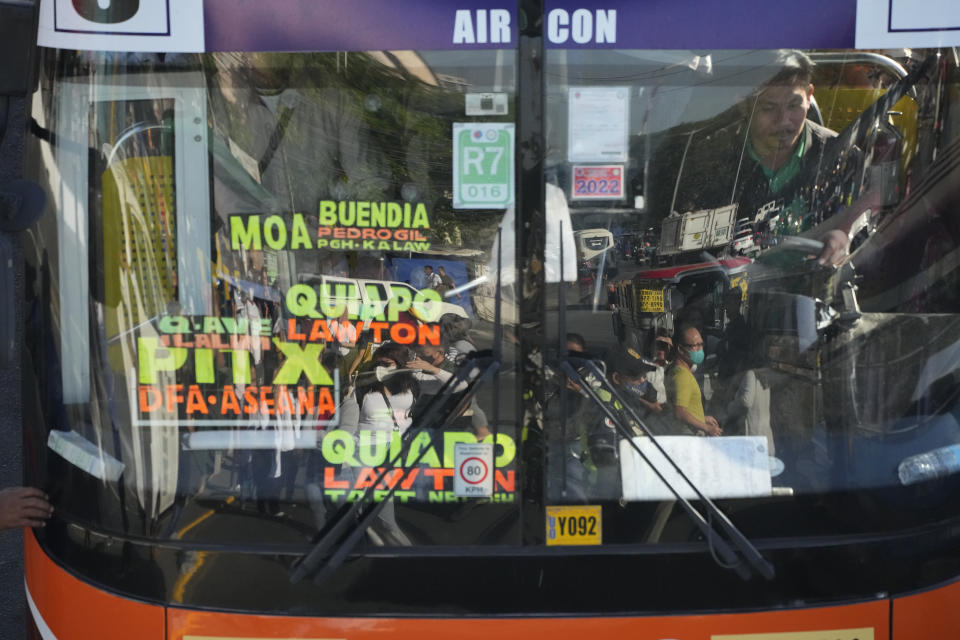 Commuters are reflected on the windshield of a bus as they wait for a ride during a transport strike in Quezon city, Philippines on Monday, March 6, 2023. Philippine transport groups launched a nationwide strike Monday to protest a government program drivers fear would phase out traditional jeepneys, which have become a cultural icon, and other aging public transport vehicles. (AP Photo/Aaron Favila)