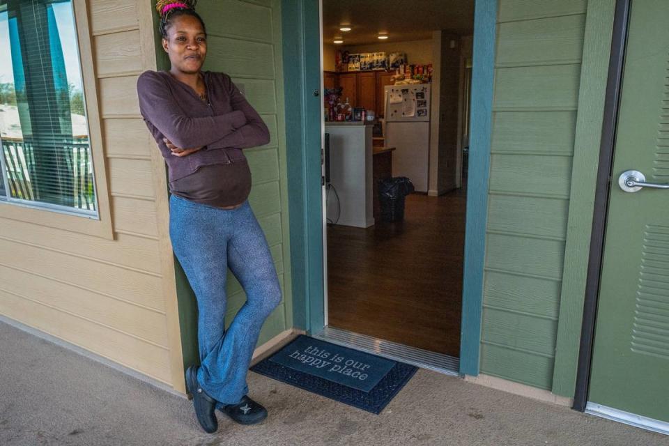 Marquisha Brown stands in April outside the low-income housing apartment, where the doormat reads “this is our happy place,” that she shares with her son. Brown credits the Yolo Basic Income program for bringing stability to their lives. “Before I moved here I was staying at hotels, I was staying at shelters, sometimes sleeping in my car – thanks to YOBI, I don’t have to do those things anymore,” she said.