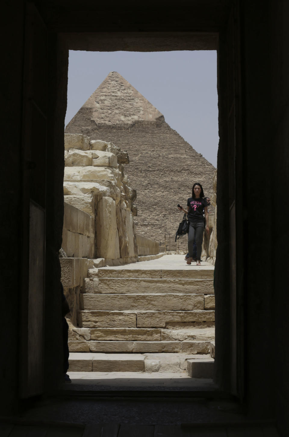 In this photo taken Friday, May 31, 2013, a tourist visits the Giza Pyramids in Giza, Egypt. A statement by Egypt’s Antiquities’ Ministry Saturday, June 1, 2013 says a U.S. Embassy security warning sent to citizens to be extra cautious for their safety in the area of the Pyramids is baseless. Earlier in the week, the U.S. Embassy in Cairo sent a message to its citizens warning them to “elevate their situational awareness when traveling to the Pyramids” due to a “lack of visible security or police” in the area. (AP Photo/Hiro Komae)