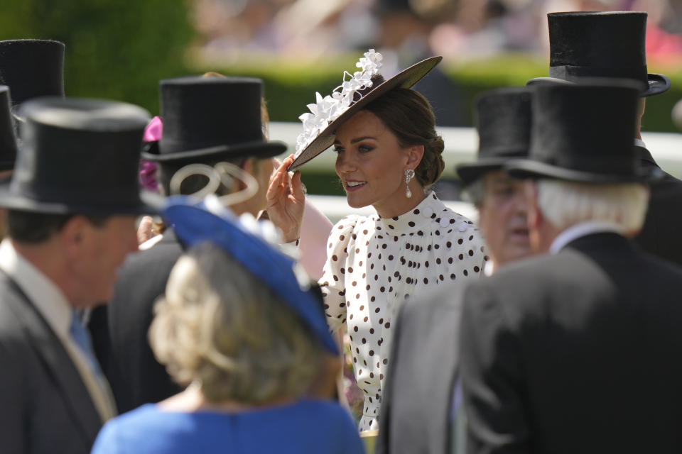 Kate, Duchess of Cambridge, center, stands in the paddock on the fourth day of the Royal Ascot horserace meeting, at Ascot Racecourse, in Ascot, England, Friday, June 17, 2022. (AP Photo/Alastair Grant)
