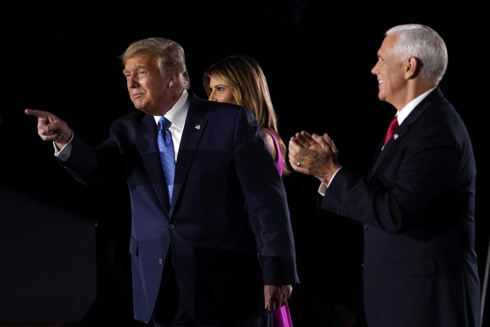 Donald Trump points to supporters as he joins Vice President Mike Pence and first Lady Melania Trump on stage (AP)