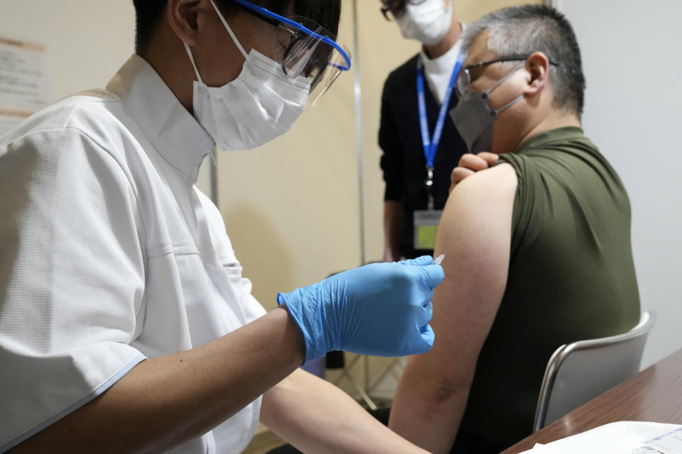 A local resident receives the booster shot of the Moderna coronavirus vaccine at a mass vaccination center operated by Japanese Self-Defense Force Monday, Jan. 31, 2022, in Tokyo. (AP Photo/Eugene Hoshiko, Pool)