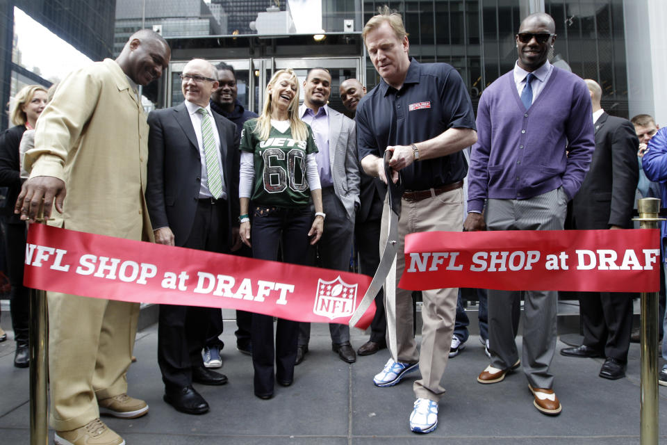 NFL Commissioner Roger Goodell, second from right, is joined by Terrell Owens, right, New York Jets owner Woody Johnson, second from left, and Johnson's wife Suzanne, center left, as he cuts the ribbon during the grand opening of the NFL Shop at Draft store, Monday, April 2, 2012 in New York. (AP Photo/Mary Altaffer)