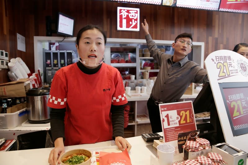 Employees work at a pork bun chain restaurant Xishaoye in Beijing