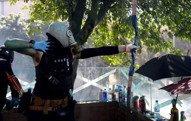 An anti-government protester uses a bow during clashes with police outside Hong Kong Polytechnic University