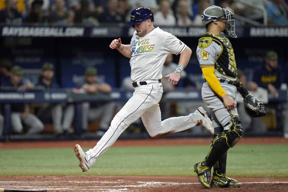 Tampa Bay Rays' Luke Raley scores past Milwaukee Brewers catcher William Contreras (24) on a sacrifice fly by Francisco Mejia during the eighth inning of a baseball game Friday, May 19, 2023, in St. Petersburg, Fla. (AP Photo/Chris O'Meara)