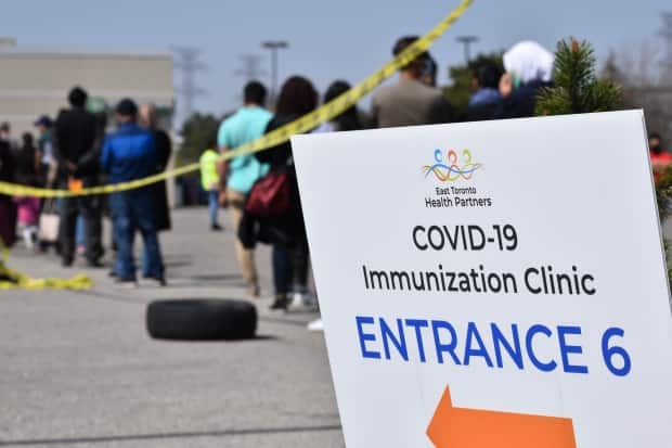 A recent lineup at a mass COVID-19 immunization clinic at the Thorncliffe Park Community Hub health centre in East York Town Centre in Toronto is shown here. Toronto has 48 vaccination clinics operating this weekend. (Alan Habbick/CBC - image credit)