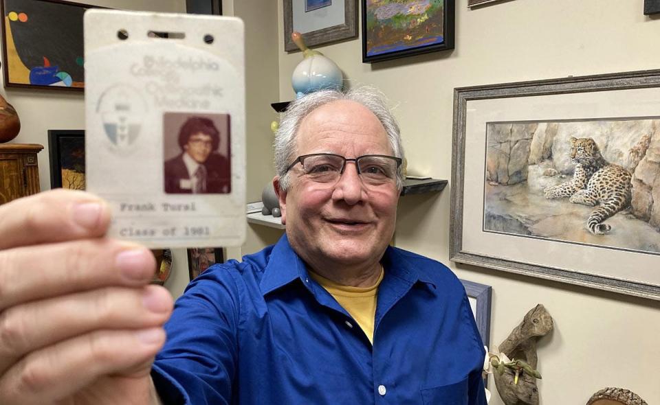 Dr. Frank Tursi, 67, holds an identification card from his medical school more than 40 years ago. Tursi, a LECOM Health family physician, has seen patients in Erie since 1982.