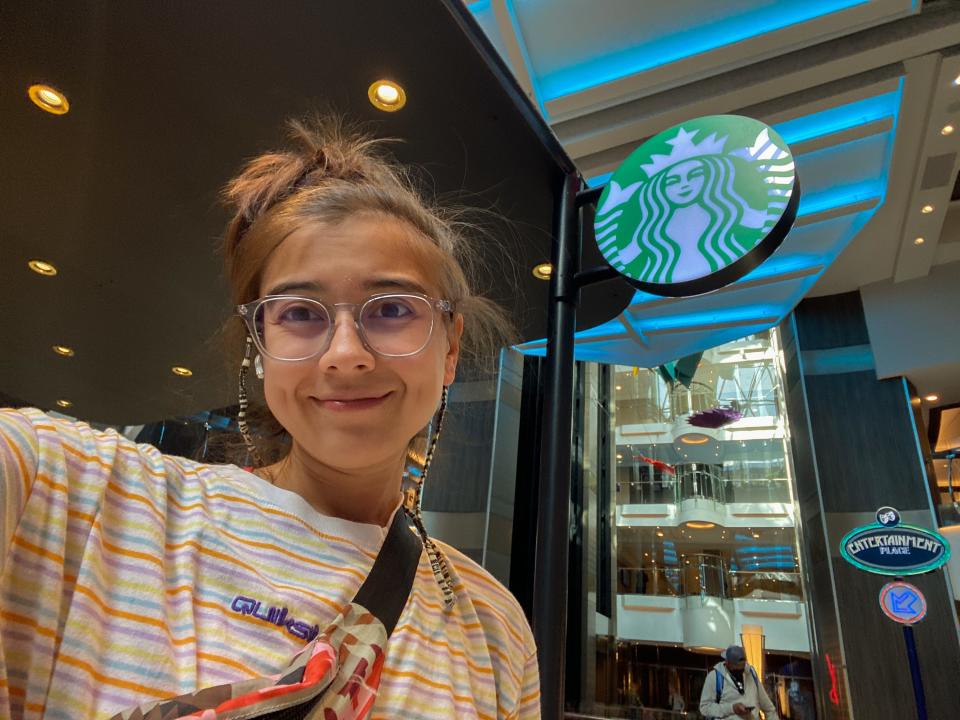 The author takes a selfie at a starbucks stand on the world's largest cruise ship