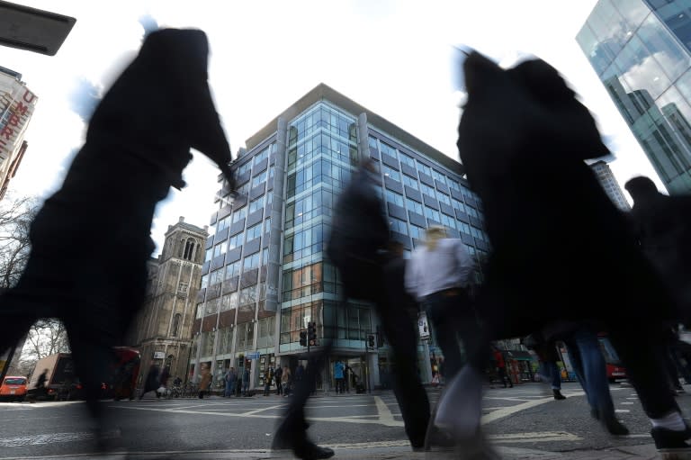 Pedestrians pass the shared building which houses the offices of Cambridge Analytica in central London on March 21, 2018