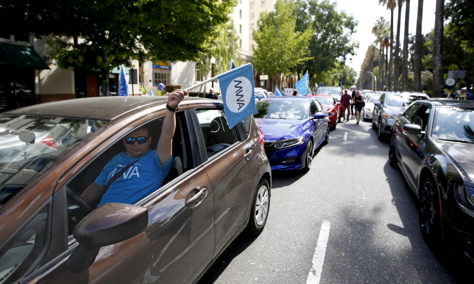 FILE - In this Aug. 28, 2019, file photo, dozens of supporters of a measure to limit when companies can label workers as independent contractors circle the Capitol during a rally in Sacramento, Calif. Ride-share company Uber and on-demand meal delivery service Postmates sued Monday, Dec. 30, 2019, to block a broad new California law aimed at giving wage and benefit protections to people who work as independent contractors. The lawsuit filed in U.S. court in Los Angeles argues that the law set to take effect Wednesday, Jan. 1, 2020, violates federal and state constitutional guarantees of equal protection and due process. (AP Photo/Rich Pedroncelli, File)