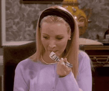 Lisa Kudrow as Phoebe Buffay from Friends eats food with a fork and cringes.