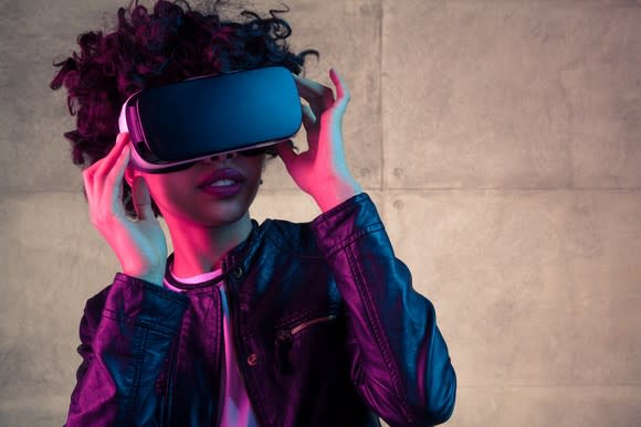 A young woman uses a VR headset.