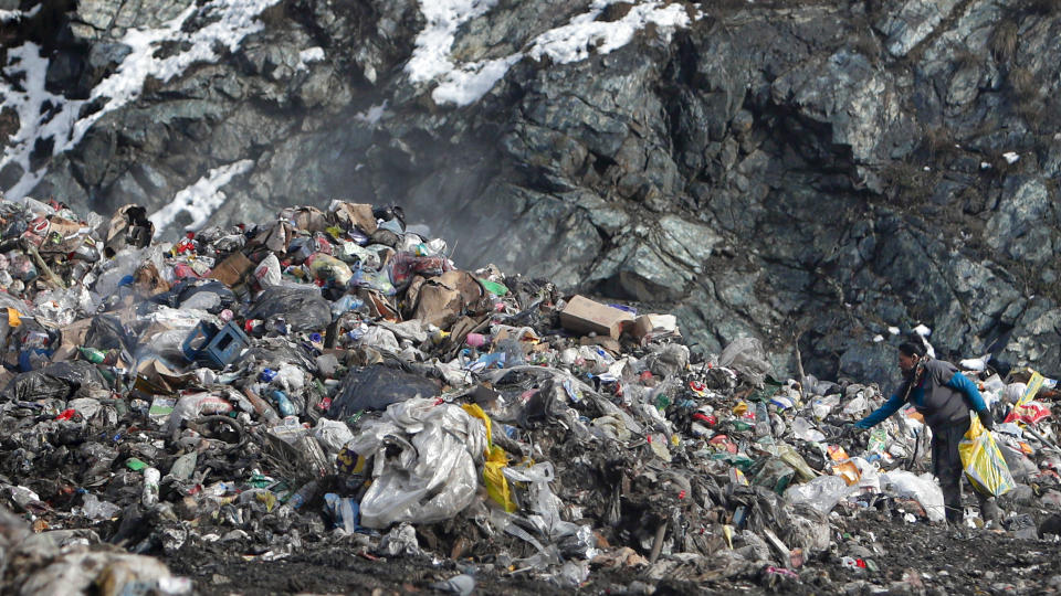 A trash collector searches for recyclable material at the landfill near Priboj, in southwest Serbia, Friday, Jan. 22, 2021. Serbia and other Balkan nations are virtually drowning in communal waste after decades of neglect and lack of efficient waste-management policies in the countries aspiring to join the European Union. (AP Photo/Darko Vojinovic)