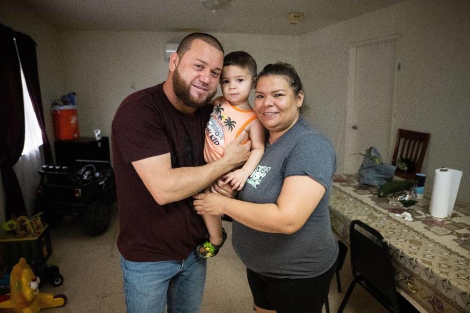 Juan Manuel Chapa y su esposa, Jessica Vela, sostienen a su hijo Jannick Dariel Chapa en su apartamento del Centro de Migrantes Williams en julio.