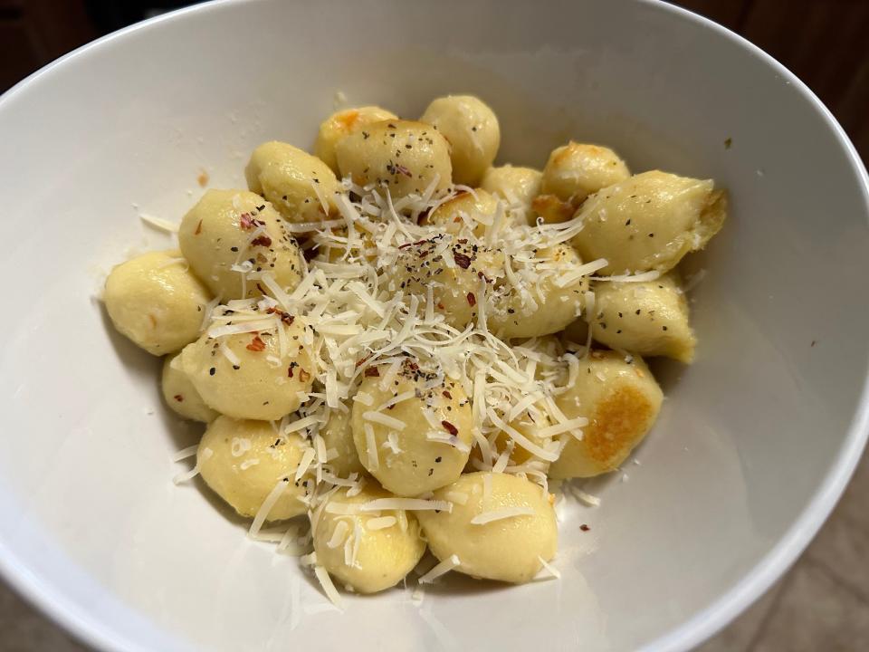 Trader Joe's outside-in stuffed gnocchi in a bowl with shreds of Parmesan on top