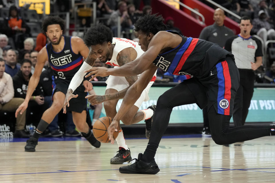 Toronto Raptors forward Jalen McDaniels (2) and Detroit Pistons center James Wiseman (13) reach for the loose ball during the first half of an NBA basketball game, Wednesday, March 13, 2024, in Detroit. (AP Photo/Carlos Osorio)