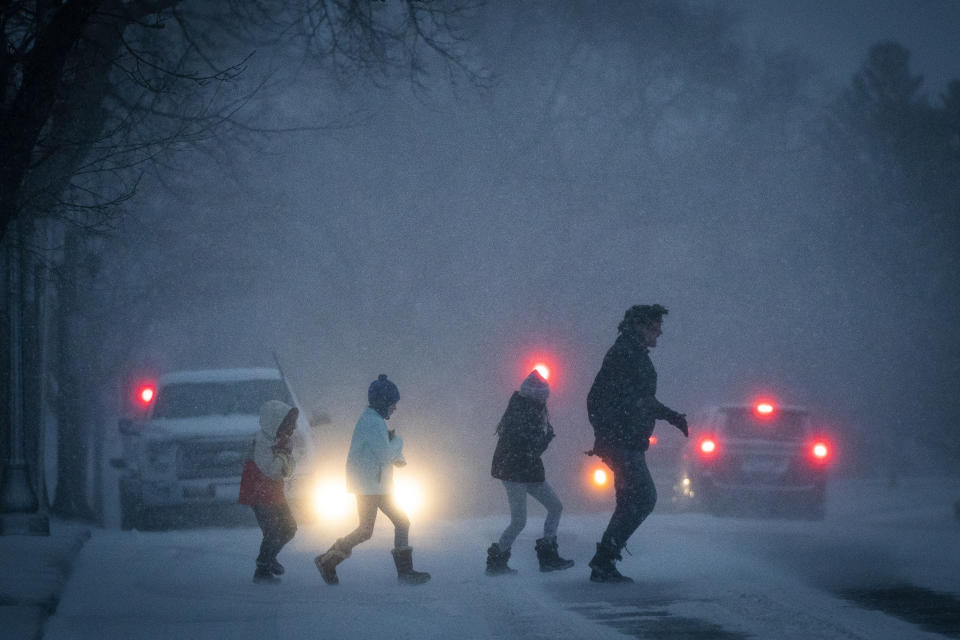 People dash across the street outside the Cathedral of St. Paul during a major winter storm, Wednesday, Dec. 23, 2020 in St. Paul, Minn. (Leila Navidi/Star Tribune via AP)