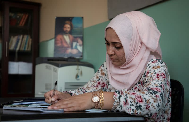 School teacher Dalal Mohammad, 45, sits at her desk at a school in Qamishli