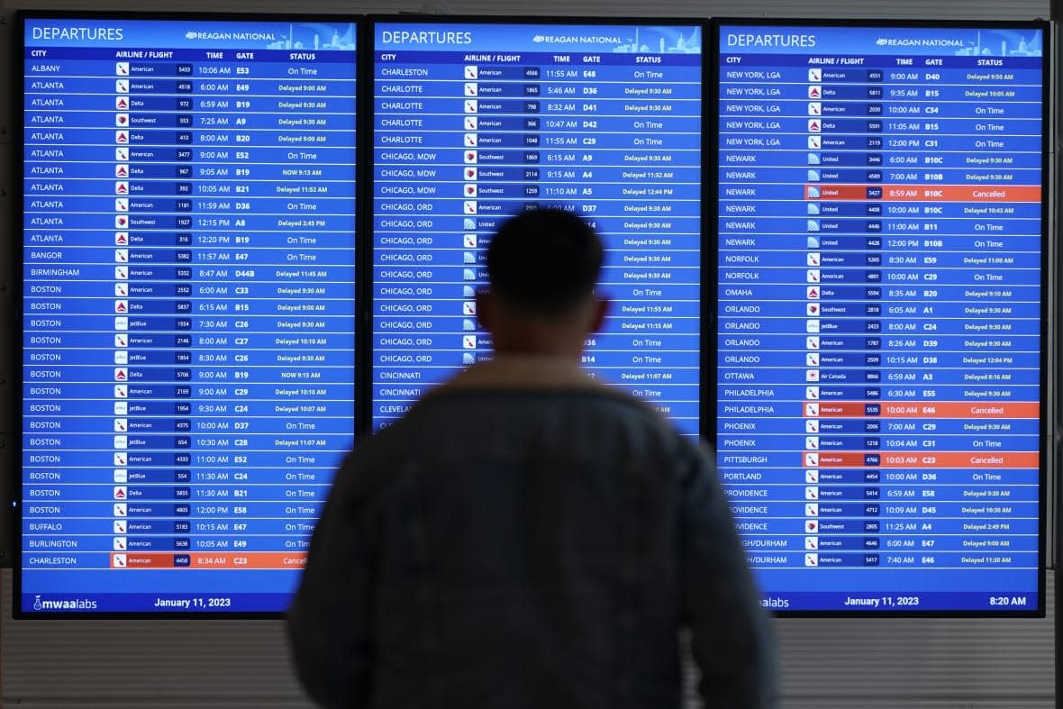 A traveler looks at a flight board with delays and cancellations at Ronald Reagan Washington National Airport in Arlington, Va., Wednesday, Jan. 11, 2023. Thousands of travelers were stranded at U.S. airports due to an hours-long computer outage. If a flight is canceled, experts say most airlines will rebook you on the next available flight. But if you choose to cancel the trip, airlines must provide you with a full refund. (AP Photo/Patrick Semansky)