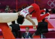 A judge watches as Kohei Uchimura of Japan falls off the pommel horse during the men's gymnastics team final in the North Greenwich Arena during the London 2012 Olympic Games July 30, 2012.