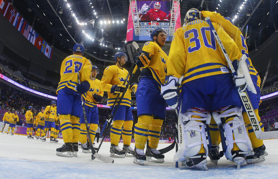 Swedish players congratulate goaltender Henrik Lundqvist on a shutout against Switzerland after a men's ice hockey game at the 2014 Winter Olympics, Friday, Feb. 14, 2014, in Sochi, Russia. Sweden won 1-0.(AP Photo/Mark Blinch, Pool)