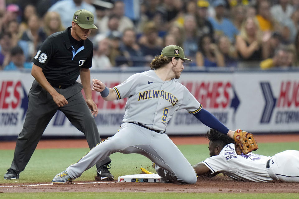 Milwaukee Brewers third baseman Brian Anderson (9) tags out Tampa Bay Rays' Randy Arozarena after he was caught trying to go from first base to third on a single by Brandon Lowe during the fourth inning of a baseball game Friday, May 19, 2023, in St. Petersburg, Fla. Making the call is umpire Vic Carapazza. (AP Photo/Chris O'Meara)