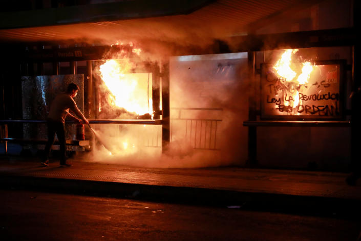 A man extinguishes fire during an anti-government protest in Santiago, Chile on Oct. 28, 2019. (Photo: Henry Romero/Reuters)