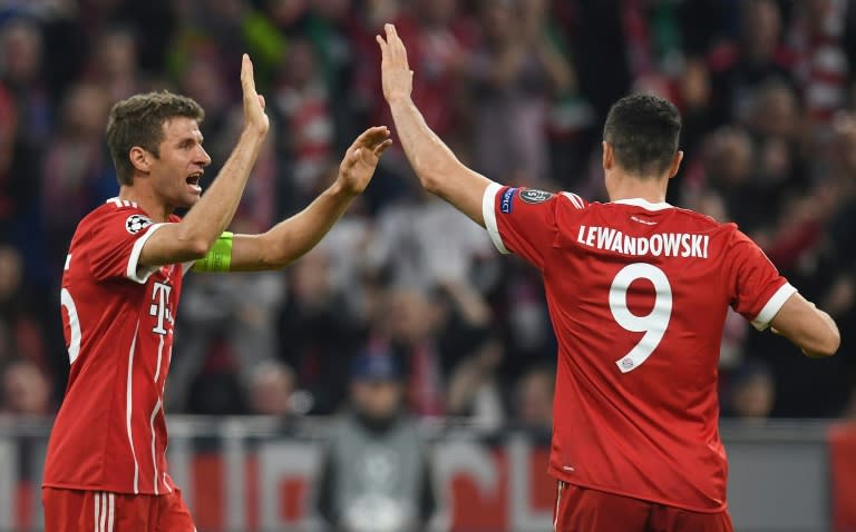 Bayern Munich's striker Thomas Mueller (L) celebrates scoring the opening goal with striker Robert Lewandowski during the Champions League match against Celtic on October 18, 2017