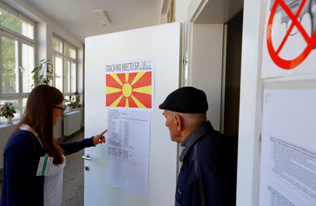 People look for their names on a voters list as they come to cast their ballot for the presidential elections in Skopje, North Macedonia April 21, 2019. REUTERS/Ognen Teofilovski