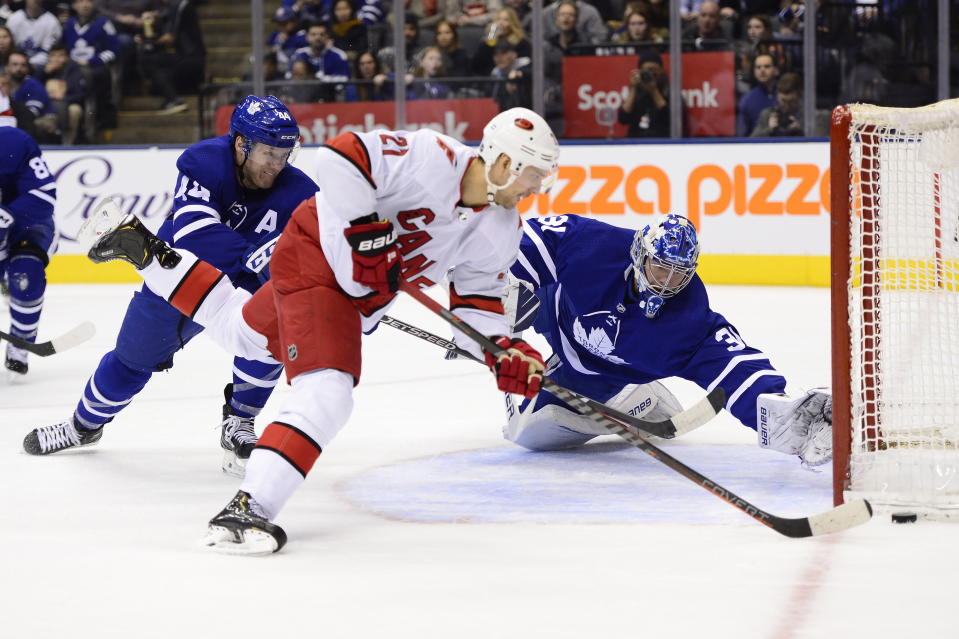 Toronto Maple Leafs goaltender Frederik Andersen (31) makes a save on Carolina Hurricanes right wing Nino Niederreiter (21) as Leafs defenceman Morgan Rielly (44) defends during first period NHL hockey action in Toronto, Monday, Dec. 23, 2019. (Frank Gunn/The Canadian Press via AP)