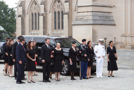 The family of the late Senator John McCain faces the car containing his casket in front of the Washington National Cathedral in Washington, U.S. September 1, 2018. REUTERS/Eric Thayer
