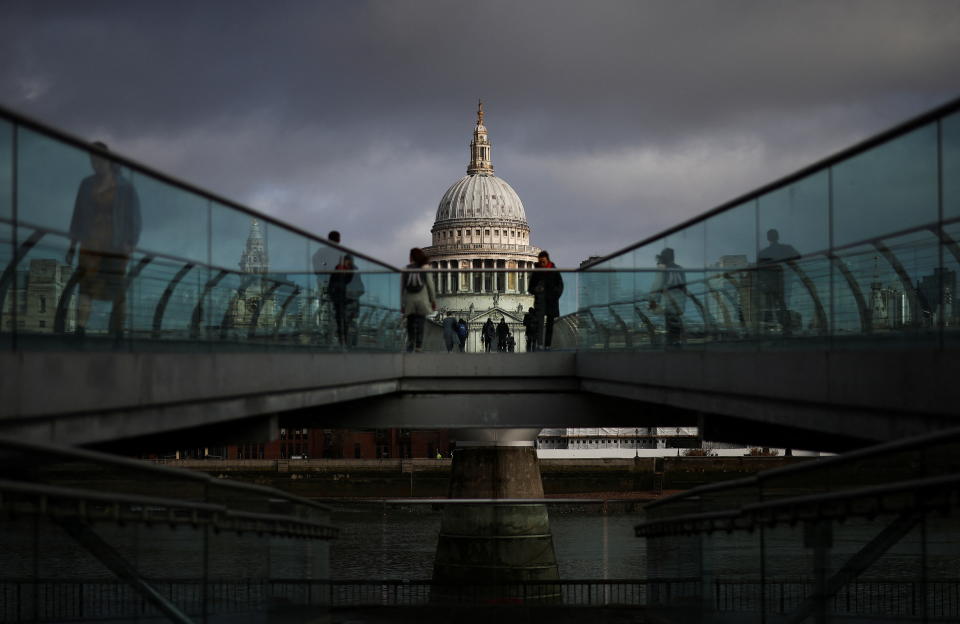 People walk over Millennium Bridge in London, UK