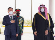 In this photo released by the Saudi Royal Palace, Saudi Crown Prince Mohammed bin Salman, right, and South Korean President Moon Jae-in, greet an honor guard at Riyadh international airport, Saudi Arabia, Tuesday, Jan. 18, 2022. It is the latest visit by a head of state to Saudi Arabia as a growing number of world leaders resume bilateral meetings and trips abroad following COVID-19 vaccine rollouts in many parts of the world. (Bandar Aljaloud/Saudi Royal Palace via AP)