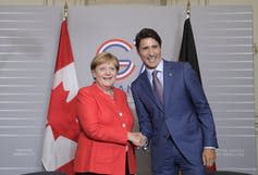 German Chancellor Angela Merkel shakes hands with Prime Minister Justin Trudeau. (AP Photo/Markus Schreiber)