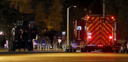 Police officers and their vehicles line the street in Redlands, California outside the house of one of the suspects in San Bernardino shooting rampage December 2, 2015. REUTERS/Mario Anzuoni