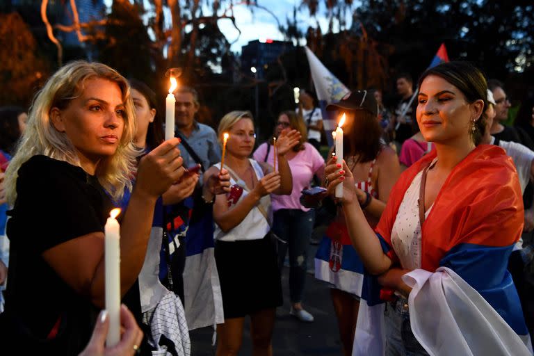 Miembros de la comunidad serbia local realizan una vigilia frente al hotel en el que fue hospedado Novak Djokovic