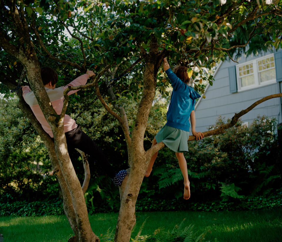 Jessie and her brother Lucas hang in a tree near their new home.<span class="copyright">Ricardo Nagaoka for TIME</span>