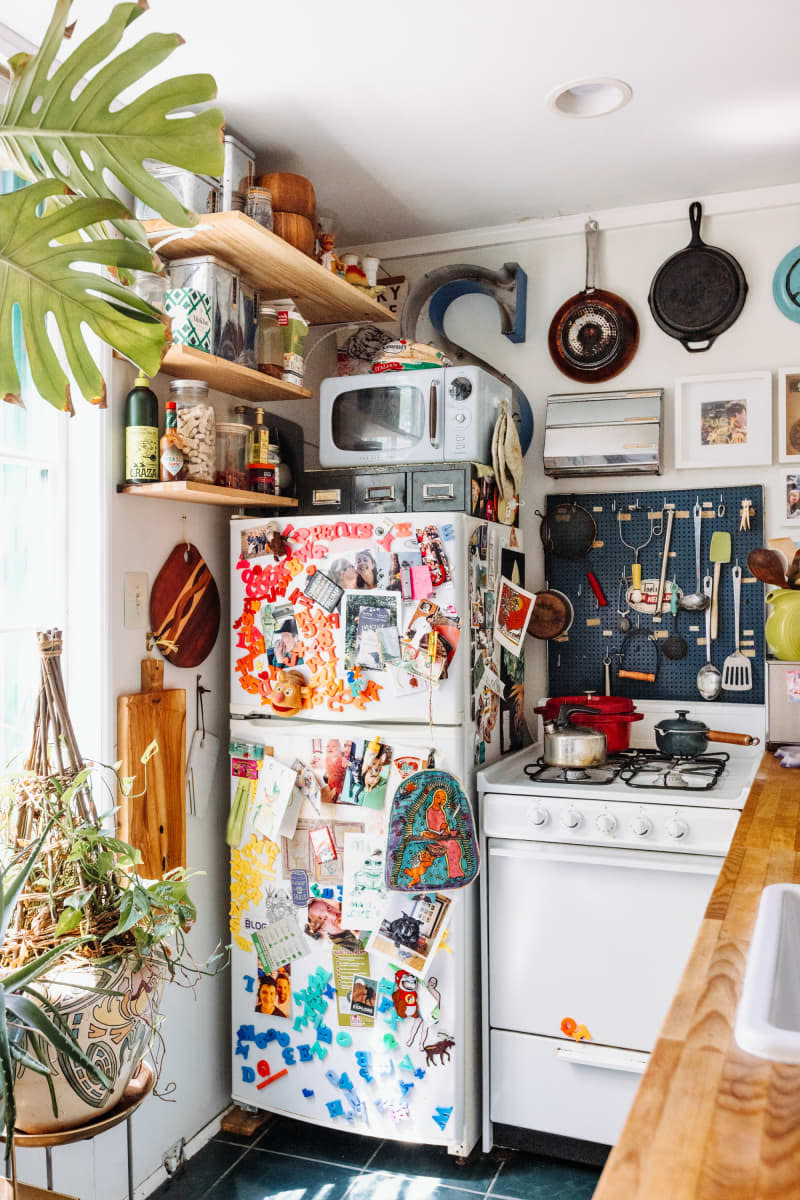 Fridge with decorative magnets and art work.