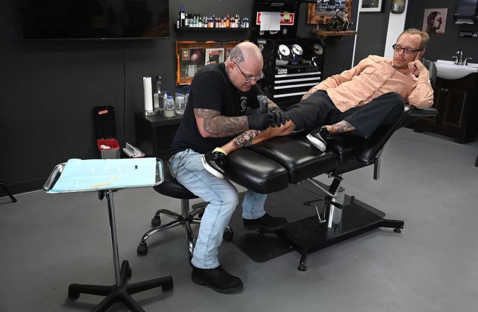 Owner and lead artist Chad Crowe works on a tattoo on Tommy Anderson, a regular customer, at Crowe’s Ink. Tattoo in Bradenton.