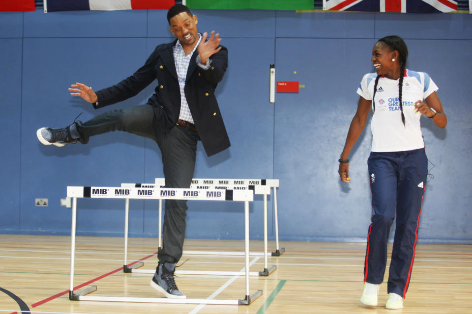 Actor Will Smith tries the hurdles with Great Britain Olympic 400m hurdler Perri Shakes-Drayton at Ethos gym in London, Wednesday, May 16, 2012. (AP Photo/Jim Ross)