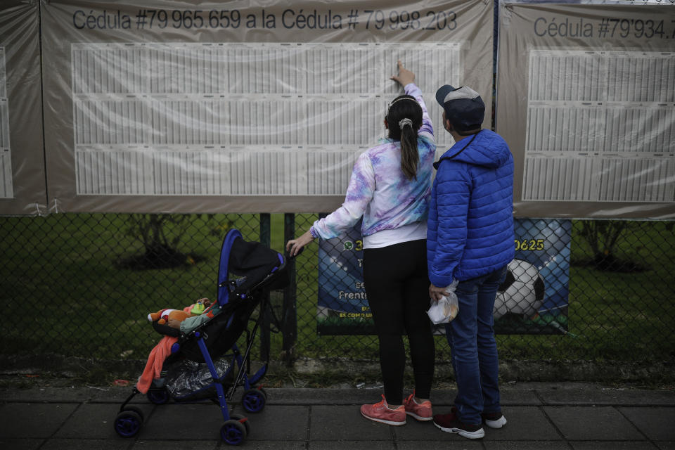 Voters look for their polling post during regional and local elections, in Bogota, Colombia, Sunday, Oct. 29, 2023. (AP Photo/Ivan Valencia)